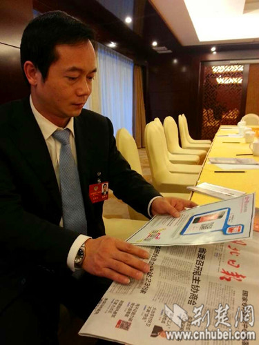 湖北省政协委员,团省委副书记吴朝安在查看湖北日报上的"神码"